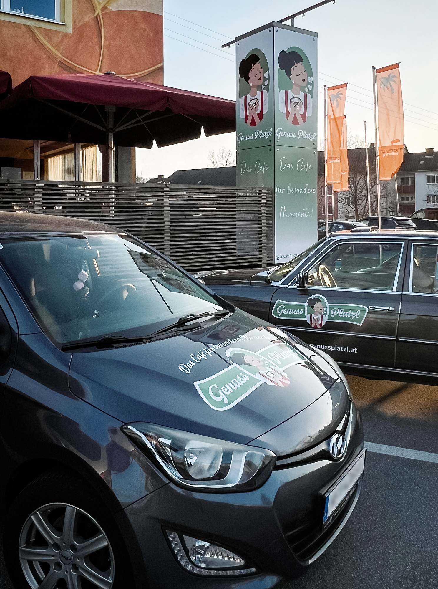 Gebrandete Fahrzeuge des glutenfreien Café Genussplatzl vor dem ipark Gebäude in Ilz