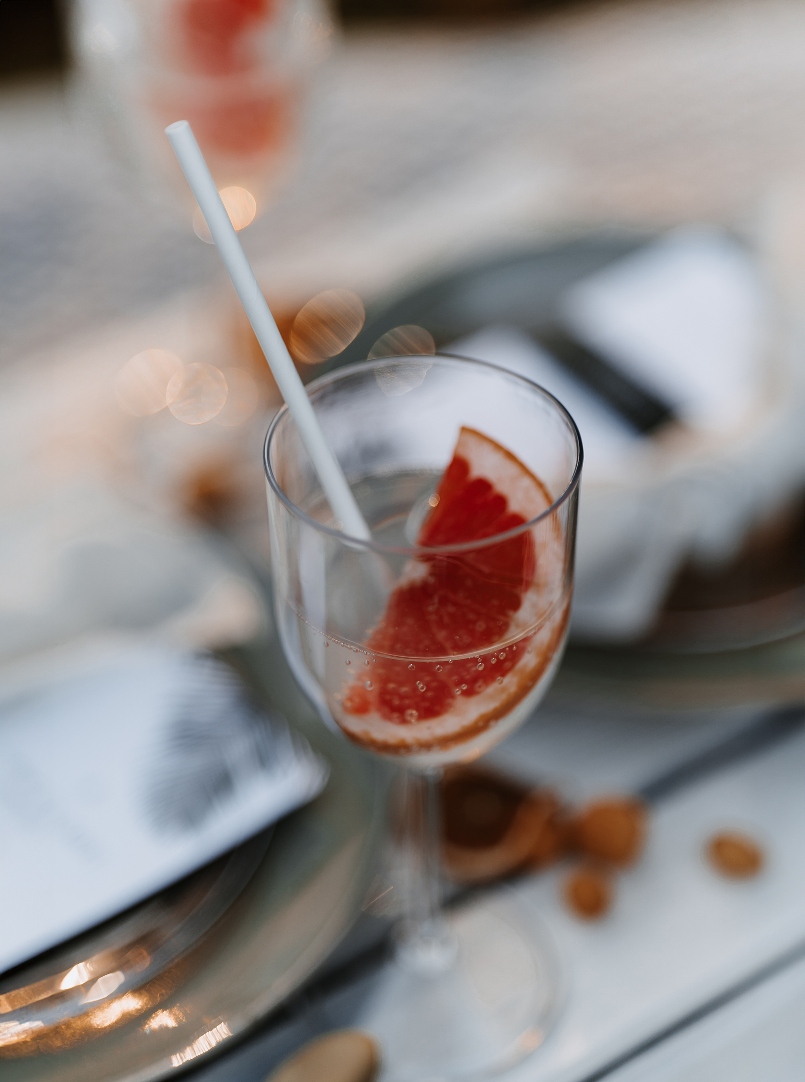Ein Glas Sekt mit einer Scheibe Grapefruit als Dekoration bei einer Hochzeit.