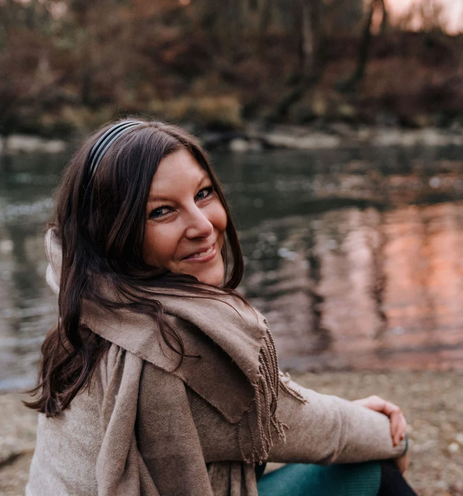 Verena, Grafikdesignerin farbgefühl aus Leibnitz, sitzt lächelnd an einem Fluss - Services-Seite, visuelles Design und Branding in der Steiermark